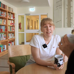 Kaksi henkilöä keskustelee kahvihuoneessa.