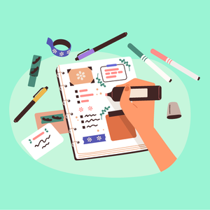 Käsi kirjoittaa kalenteriin, ympärillä on tusseja, tarroja ja teippiä vihreällä pinnalla.