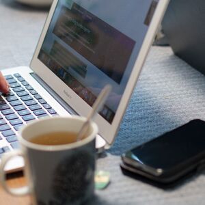 kaksi ihmistä läppäreillään pöydän ääressä