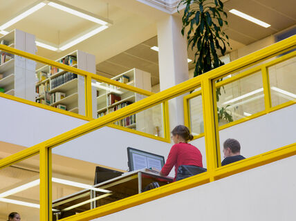 A library with people working on computers.
