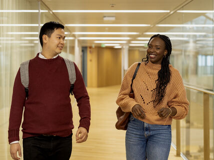 Two students walking and talking in the corridor.