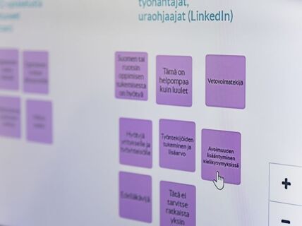 En webbsida med lila rutor som innehåller finsk text och en markör som pekar på en av rutorna. Länkar och ikoner syns.