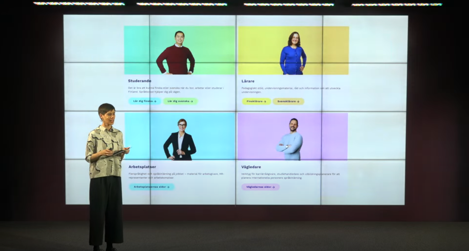 Henkilö esittelee lavalla Kielibuustin verkkosivustoa. 