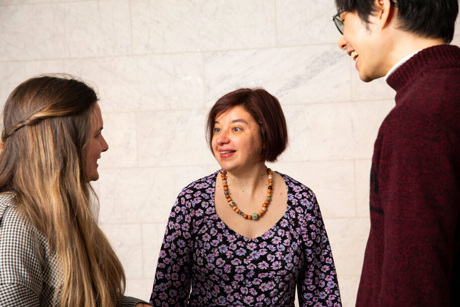 Kolme ihmistä seisoo ja puhuu. 