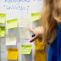 A person is reading post-it-notes attached on the whiteboard.