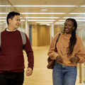 Two students walking and talking in the corridor.