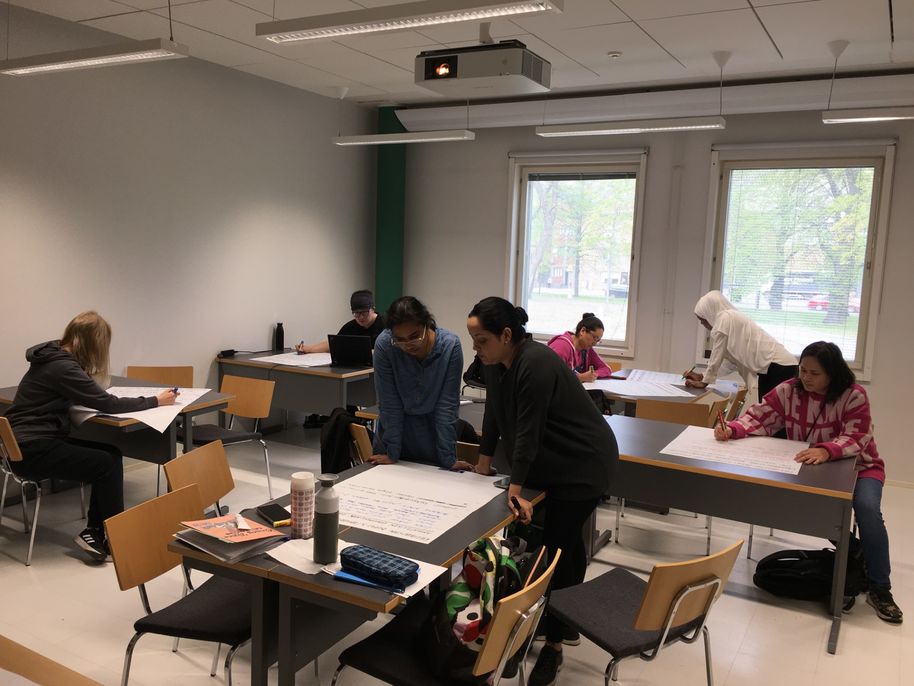 Lääkärin suomi -täydennyskoulutuksen osallistujia työskentelemässä luokkahuoneessa